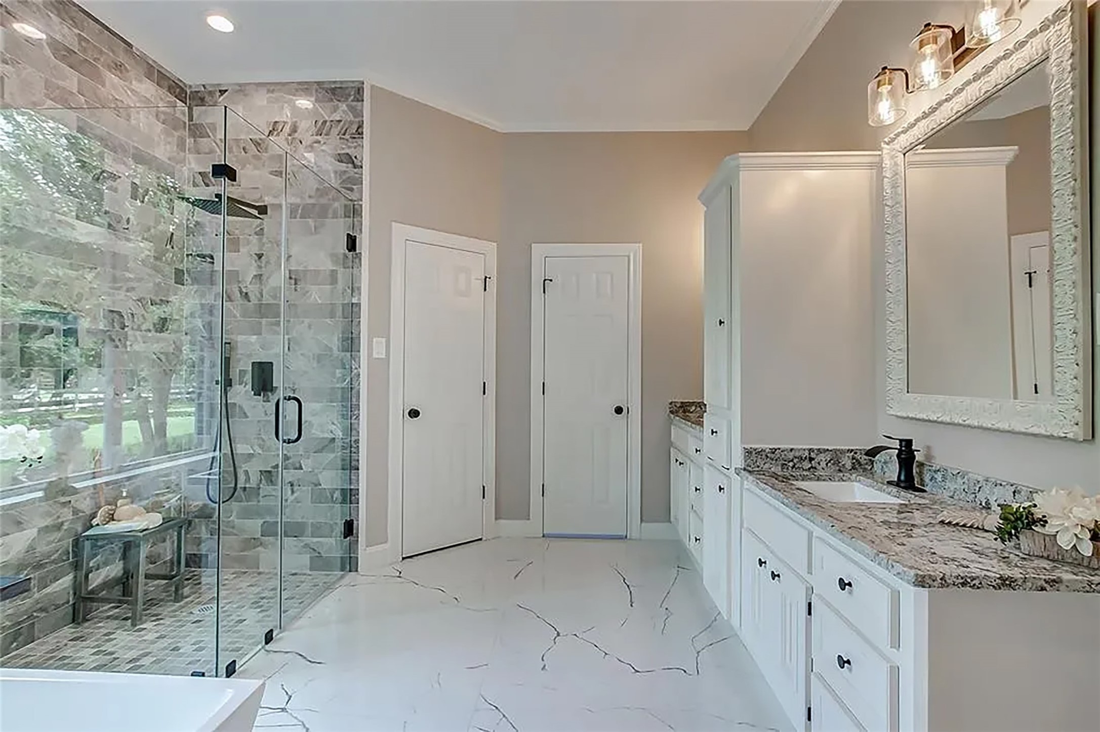 4421 Bowser Road Fulshear, TX 77441 - Photo 17 of 41 a spacious bathroom with a granite countertop sink a mirror and a shower
