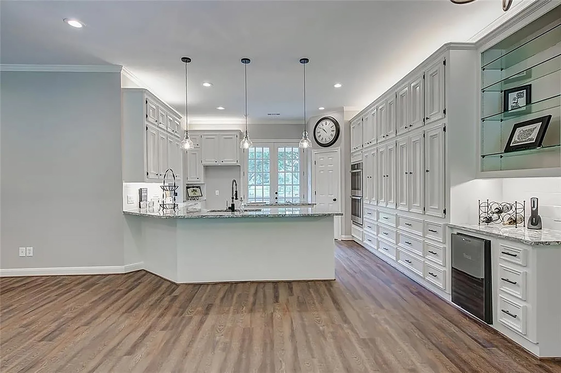 4421 Bowser Road Fulshear, TX 77441 - Photo 21 of 41 a large kitchen with cabinets wooden floor and stainless steel appliances