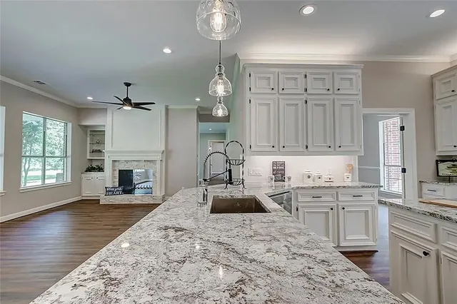 a bathroom with a granite countertop sink a toilet and shower