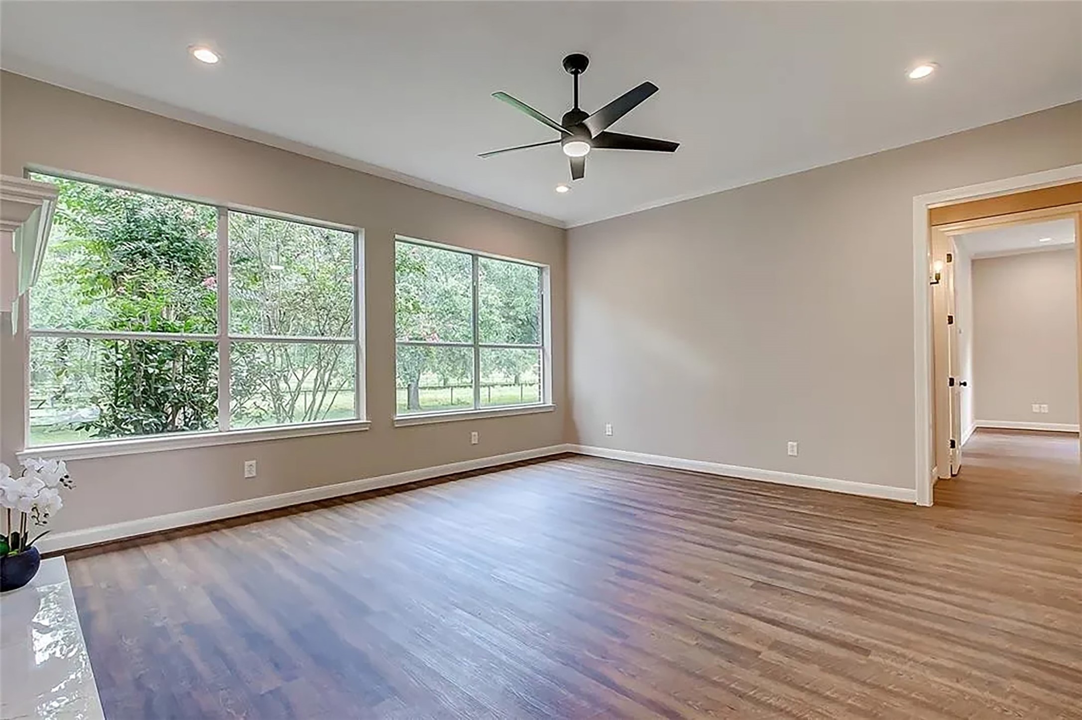 4421 Bowser Road Fulshear, TX 77441 - Photo 27 of 41 an empty room with wooden floor fan and windows
