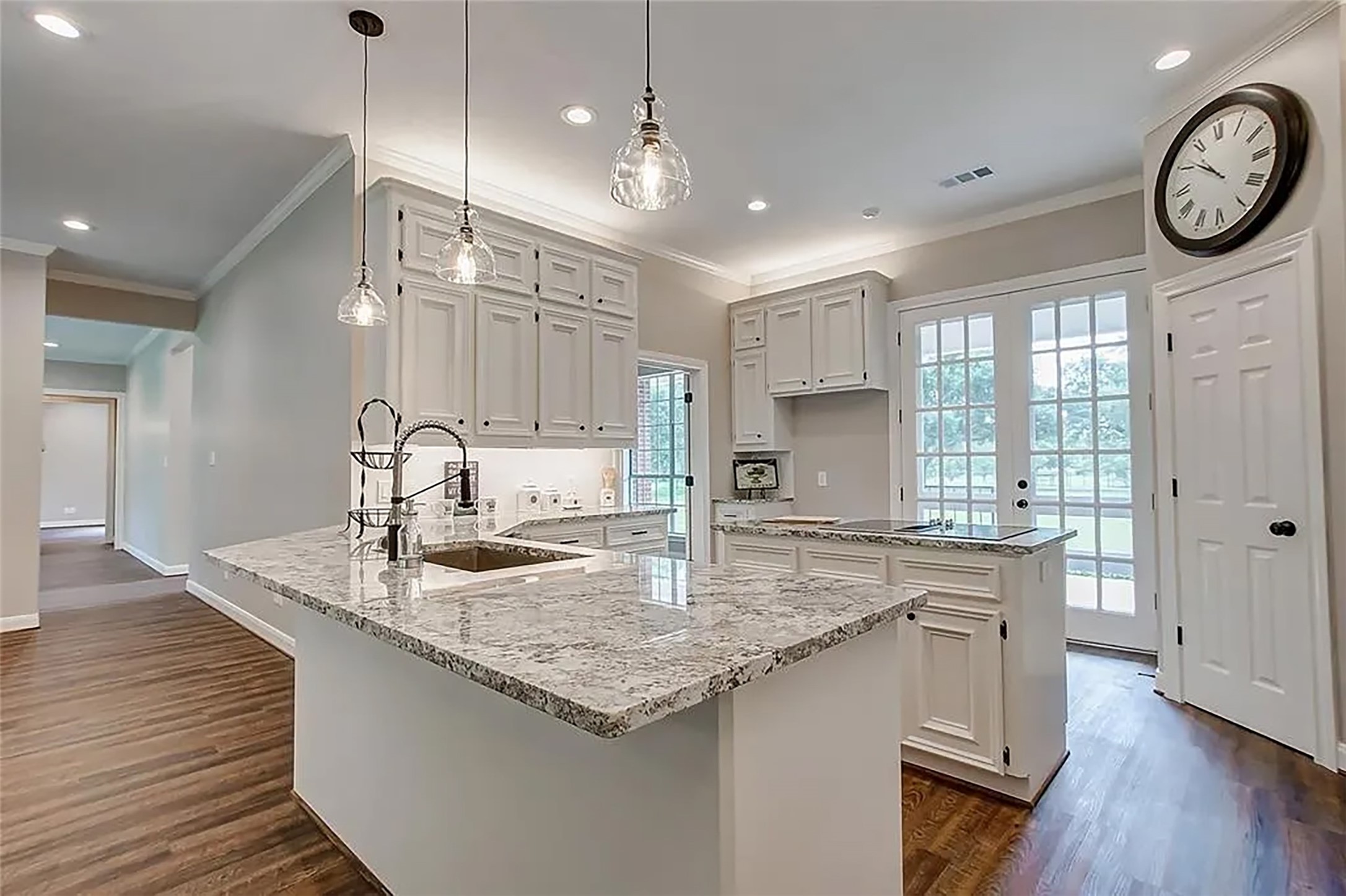 4421 Bowser Road Fulshear, TX 77441 - Photo 9 of 41 a kitchen with kitchen island granite countertop a sink a stove and wooden floors