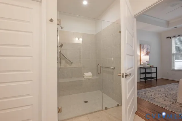 a spacious bathroom with a double vanity sink a large mirror and a shower