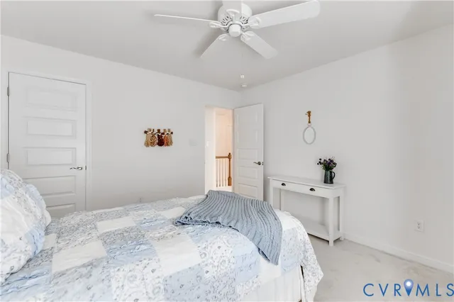 a bed sitting in a bedroom next to a window with a potted plant