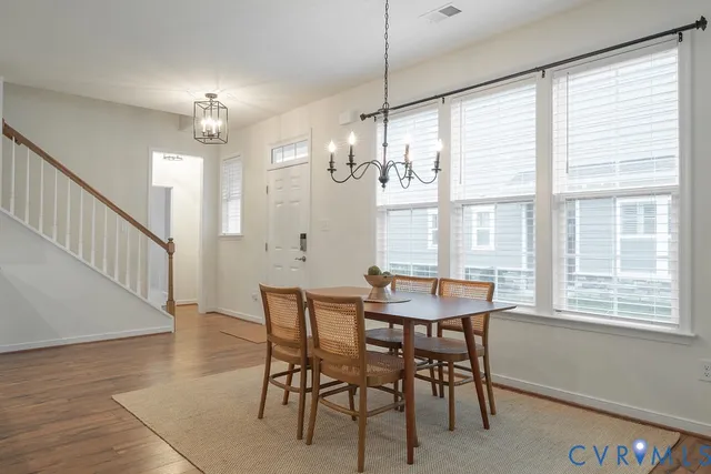 a view of a dining room with furniture a chandelier and wooden floor