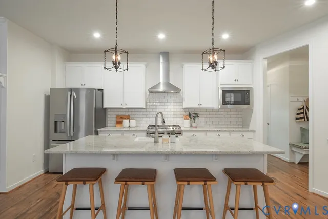 a kitchen with granite countertop a counter space cabinets stainless steel appliances and a chandelier
