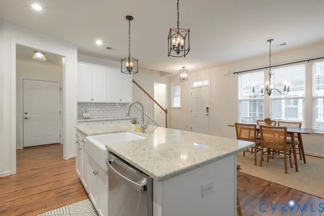 a large kitchen with kitchen island a stove a chandelier a dining table and chairs