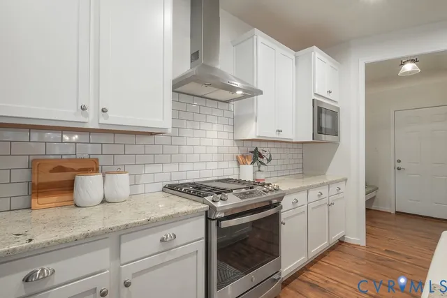 a kitchen with stainless steel appliances granite countertop a sink a stove and cabinets