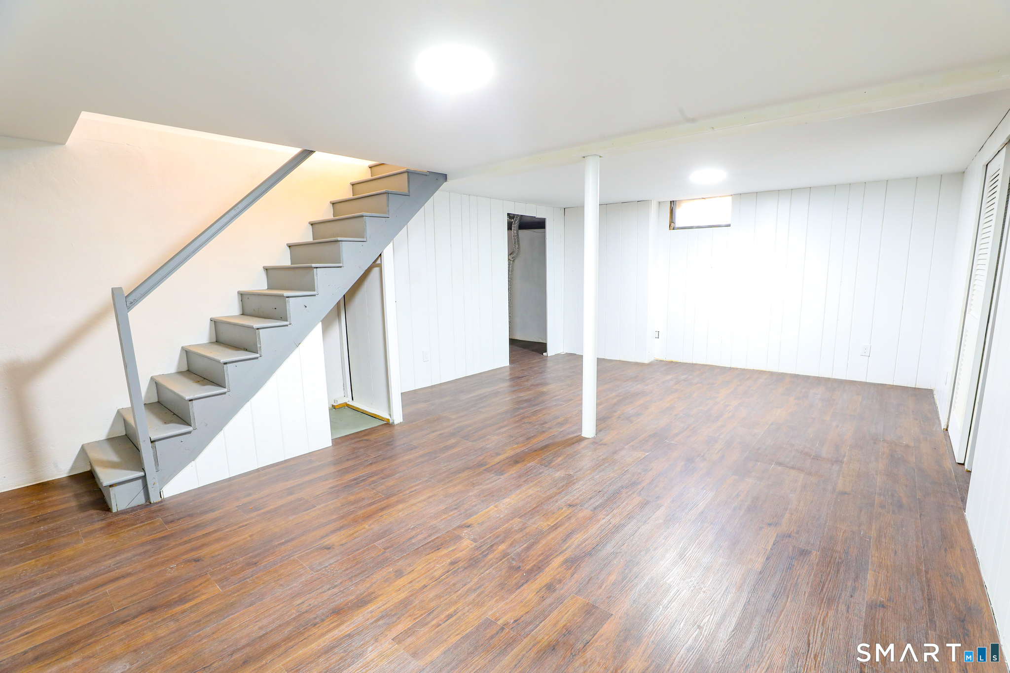 105 Hyde Road West Hartford, CT 06117 - Photo 23 of 25 a view of an empty room with wooden floor and stairs