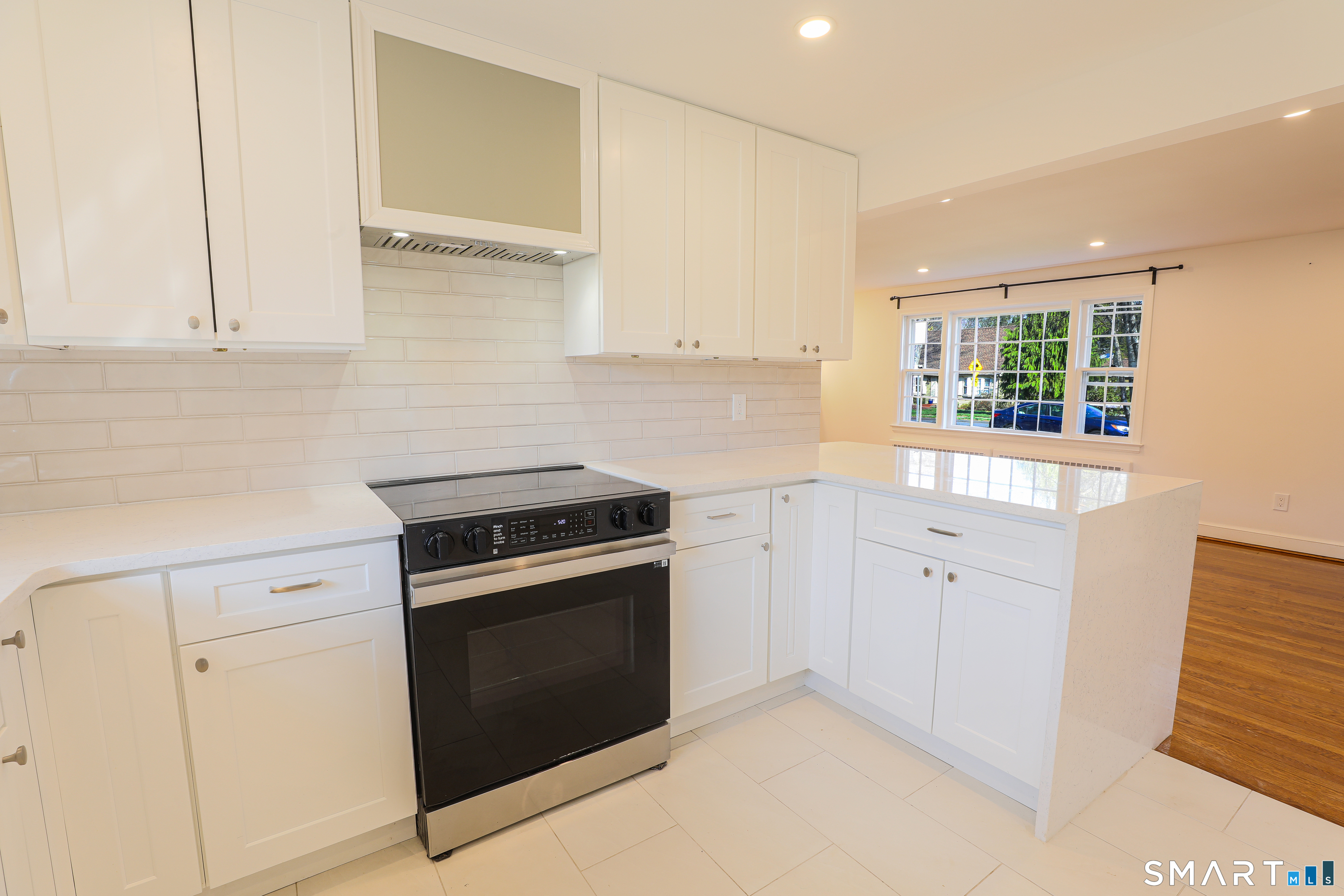105 Hyde Road West Hartford, CT 06117 - Photo 8 of 25 a kitchen with white cabinets and a stove top oven