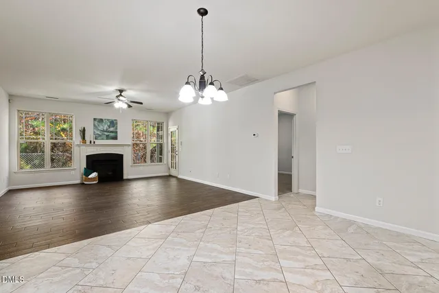 a view of empty room with fireplace and wooden floor