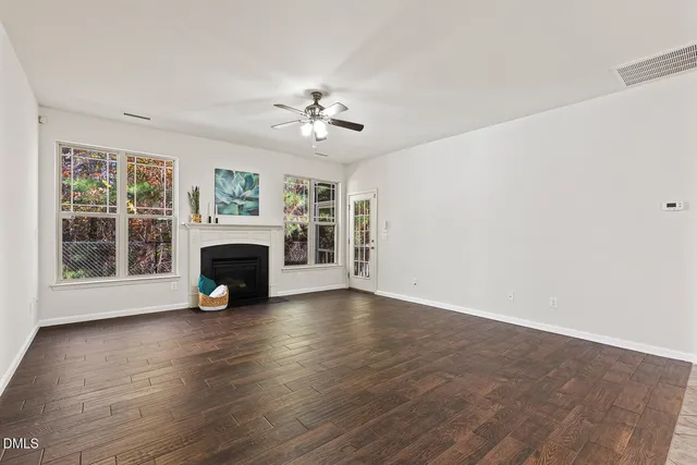 a view of an empty room with a fireplace and a window
