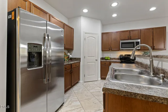 a kitchen with granite countertop a refrigerator and a sink