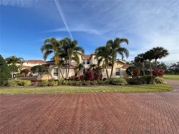 a couple of palm trees in front of yellow house