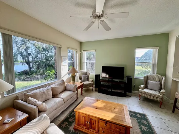 a living room with furniture a flat screen tv and a large window