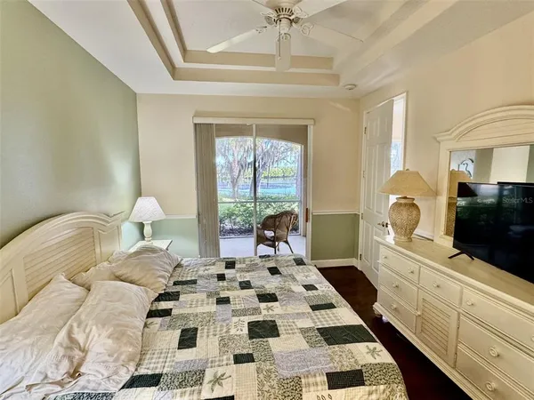 a bedroom with a bed and a flat tv screen on dresser