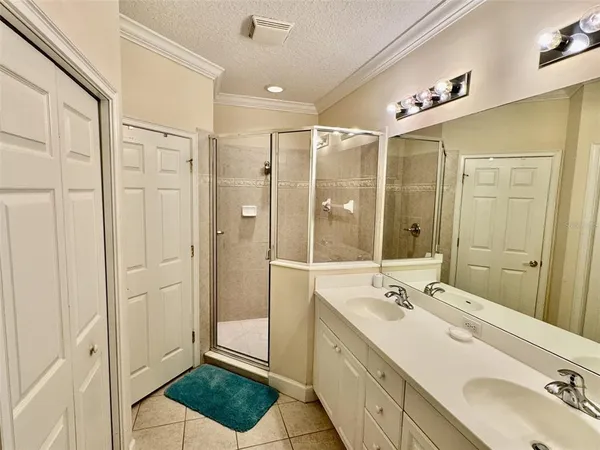 a bathroom with a double vanity sink a mirror and a shower