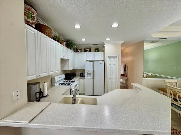 a kitchen with stainless steel appliances a sink a refrigerator and a counter top space