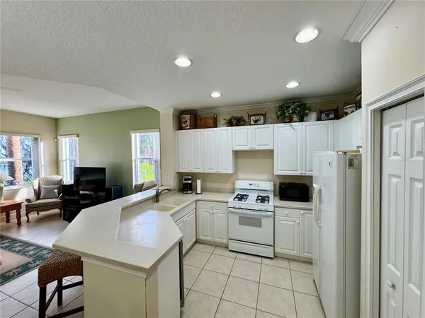a kitchen with a sink a microwave a stove and white cabinets