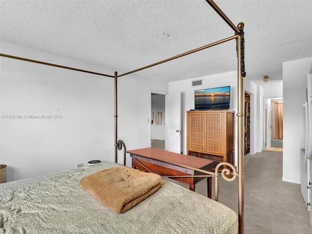 a bedroom with a bed and a dresser next to a window