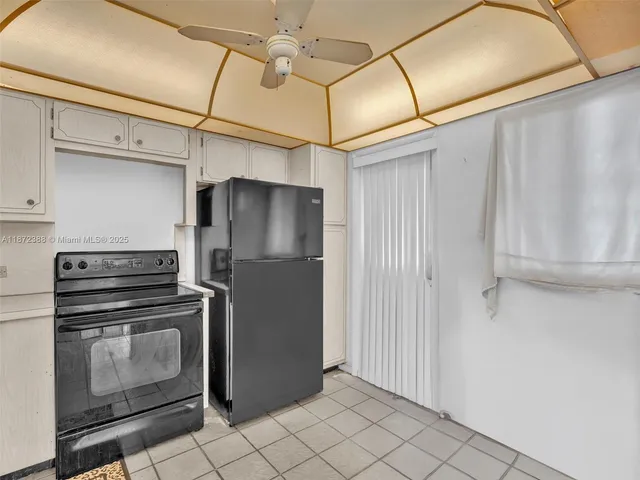 a kitchen with stainless steel appliances granite countertop a refrigerator a sink and white cabinets