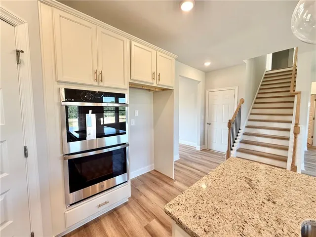 a view of a kitchen with wooden floor and staircase