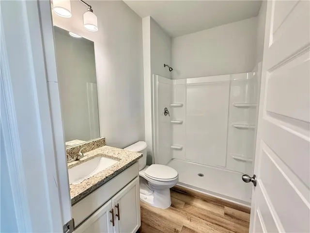 a bathroom with a granite countertop sink toilet and shower