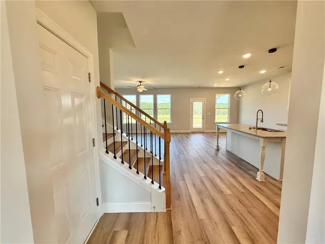 a view of staircase and kitchen with wooden floor