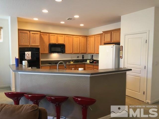 1310 Meridian Ranch Drive Reno, NV 89523 - Photo 5 of 13 a kitchen with stainless steel appliances granite countertop a refrigerator and a stove top oven
