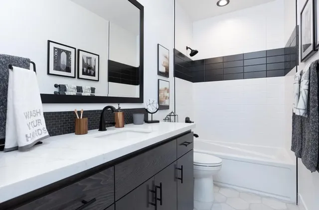 a bathroom with a double vanity sink a mirror and a bathtub