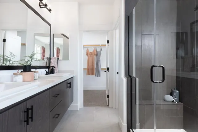 a bathroom with a double vanity sink mirror and shower