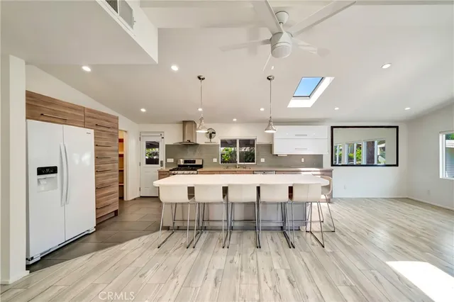 a kitchen with kitchen island granite countertop a table chairs sink and cabinets
