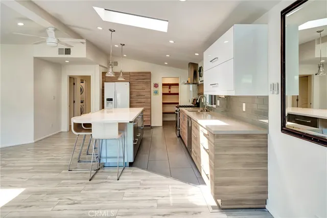 a kitchen with stainless steel appliances granite countertop a stove a sink and a refrigerator