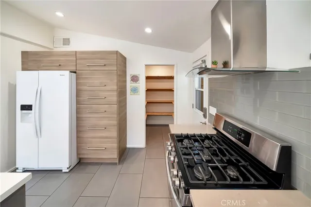 a kitchen with stainless steel appliances a stove a sink and a refrigerator