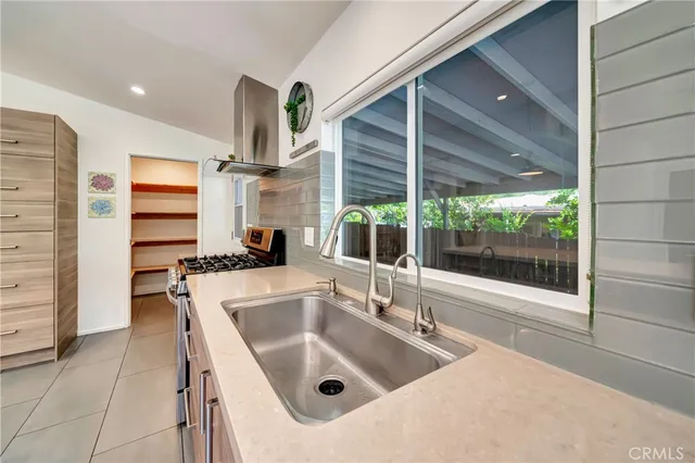 a kitchen with kitchen island a counter top space a sink stainless steel appliances and cabinets