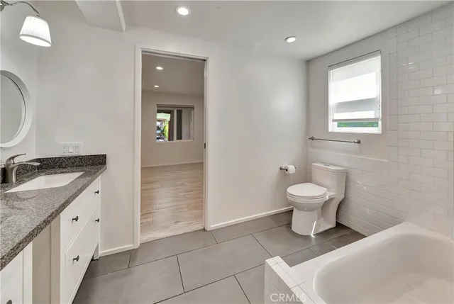 an empty room with wooden floor and a ceiling fan
