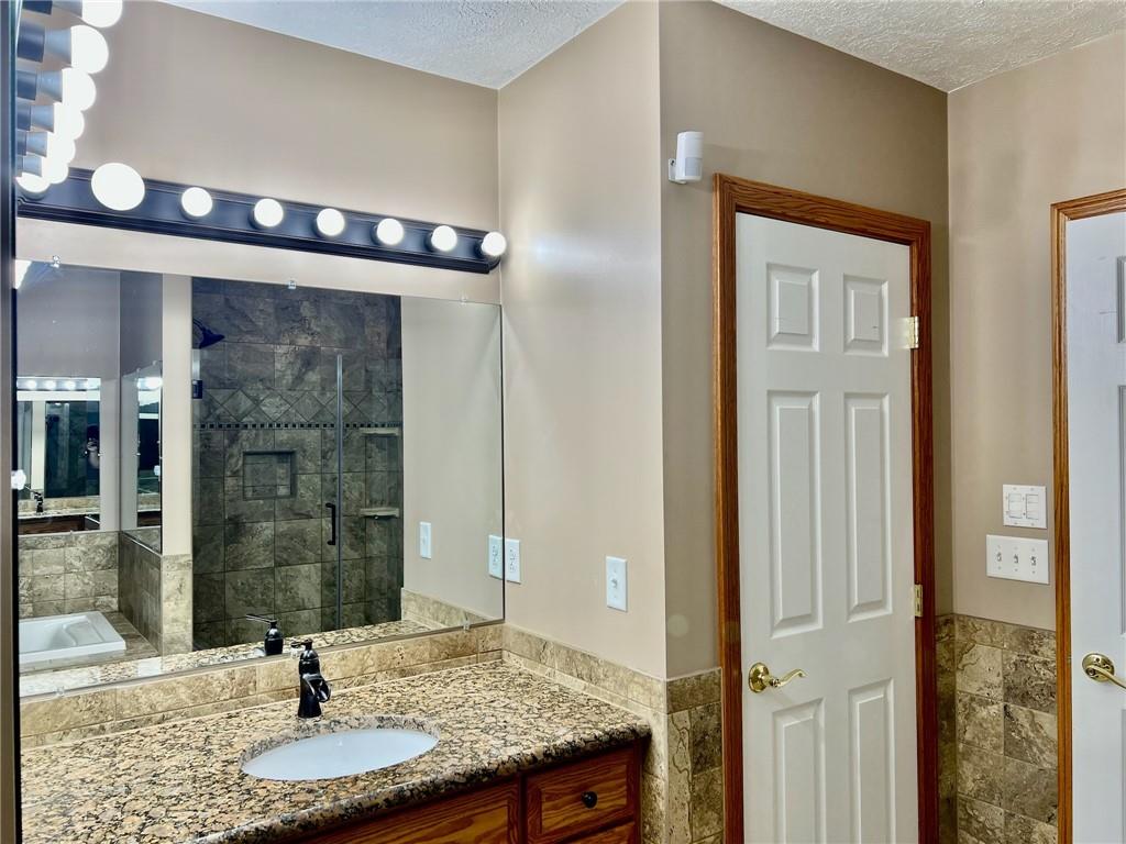 657 Fallecker Road Butler, PA 16002 - Photo 12 of 25 a bathroom with a granite countertop sink a mirror and shower
