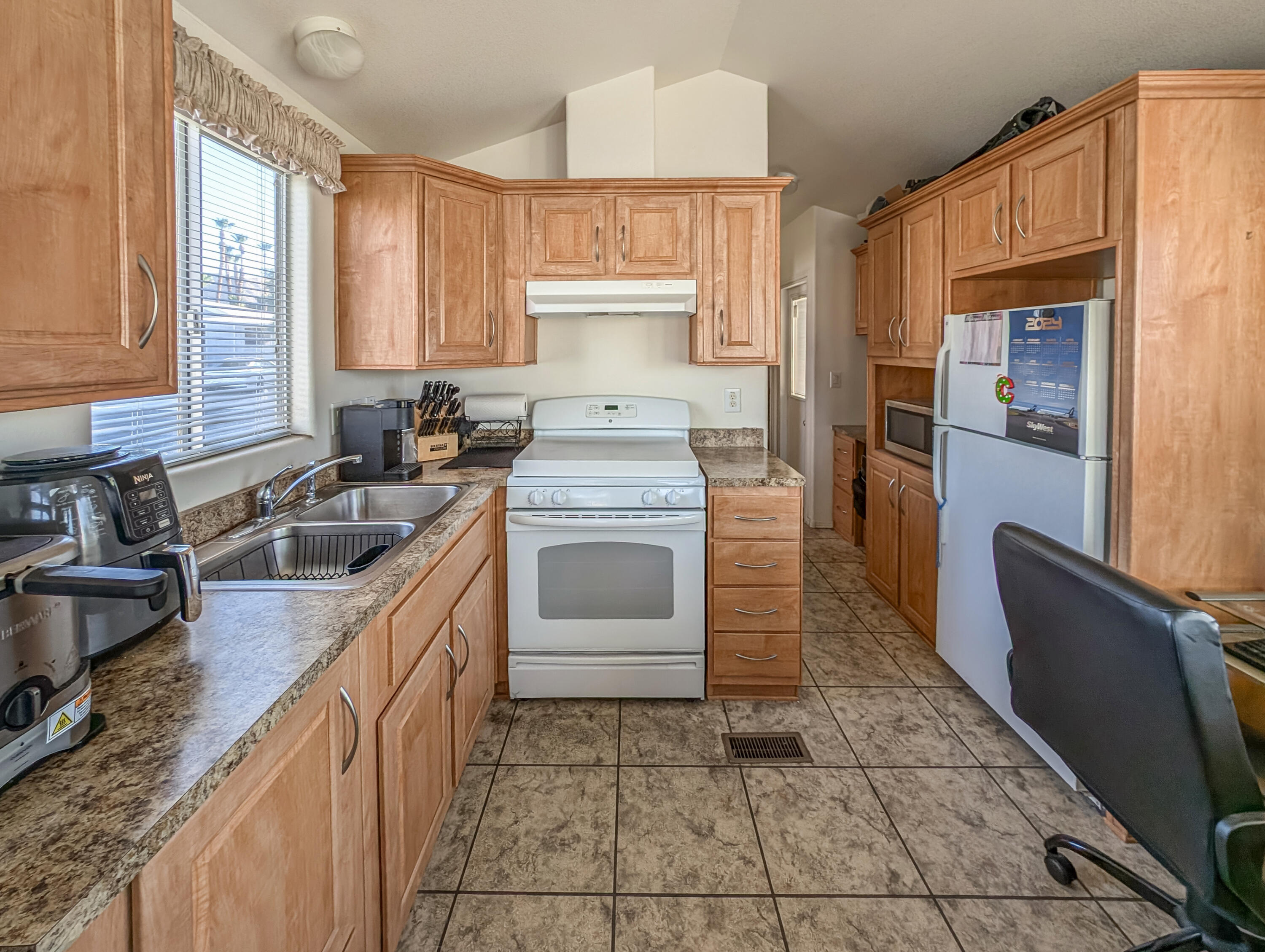 70200 Dillon Road, Unit 350 Desert Hot Springs, CA 92241 - Photo 9 of 22 a kitchen with a stove sink and cabinets