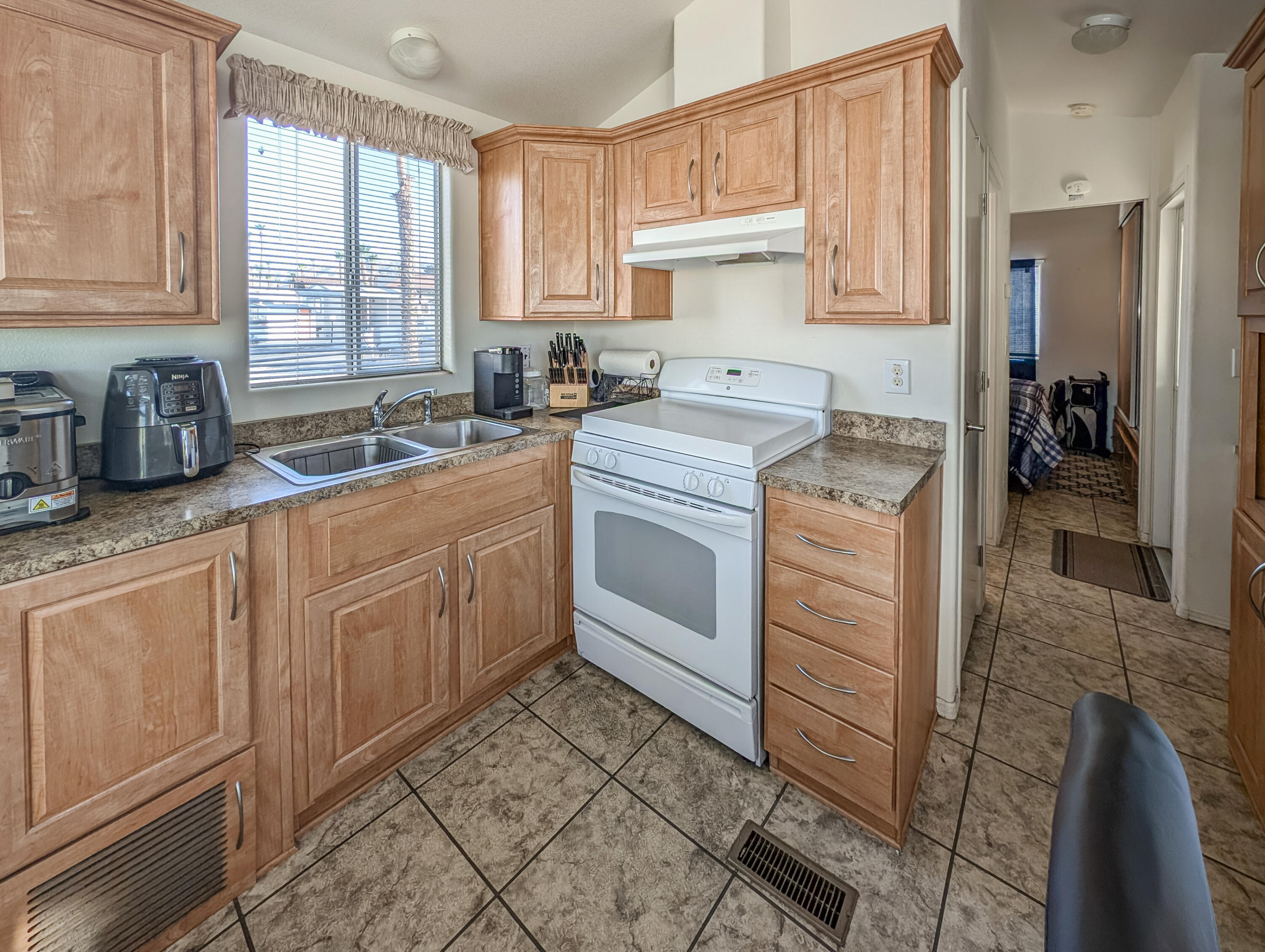 70200 Dillon Road, Unit 350 Desert Hot Springs, CA 92241 - Photo 10 of 22 a kitchen with sink cabinets and window