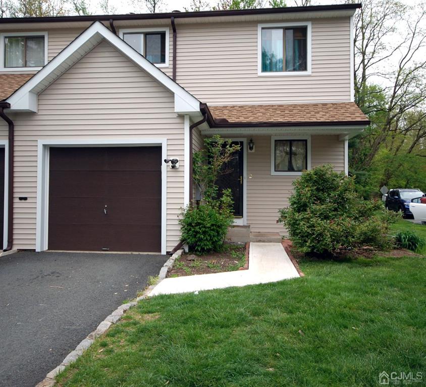 a front view of a house with a garden and garage