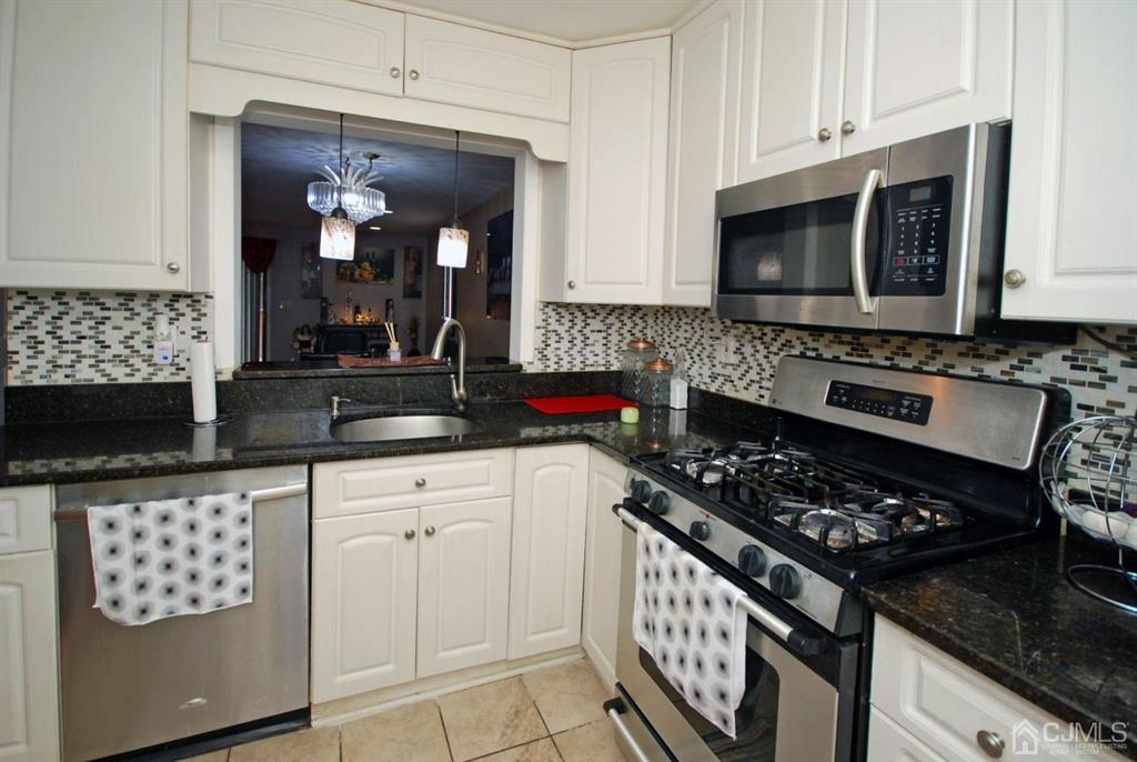 2 Tulip Court Edison, NJ 08820 - Photo 12 of 34 a kitchen with stainless steel appliances a stove a microwave a sink and cabinets