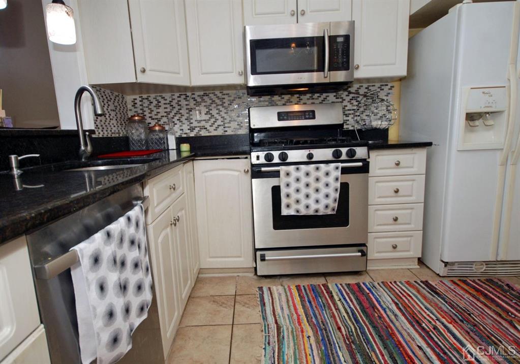 2 Tulip Court Edison, NJ 08820 - Photo 13 of 34 a kitchen with granite countertop a sink and a stove top oven