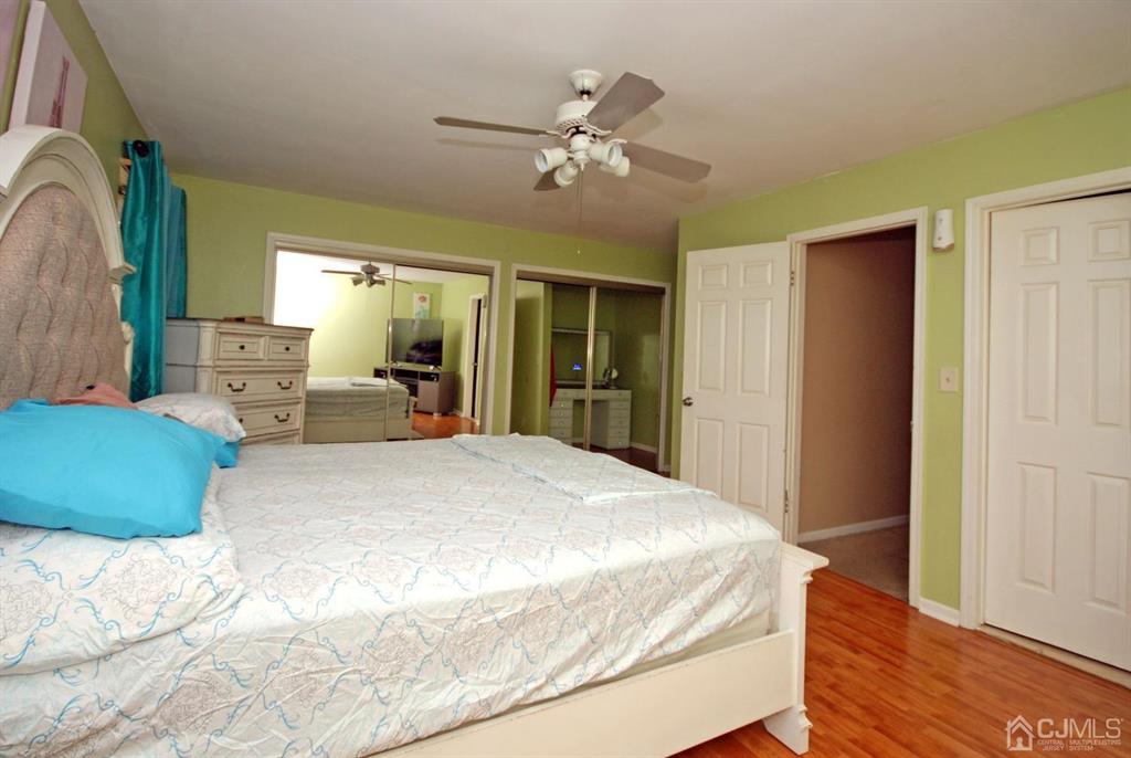 2 Tulip Court Edison, NJ 08820 - Photo 18 of 34 a bedroom with a large bed and a chandelier