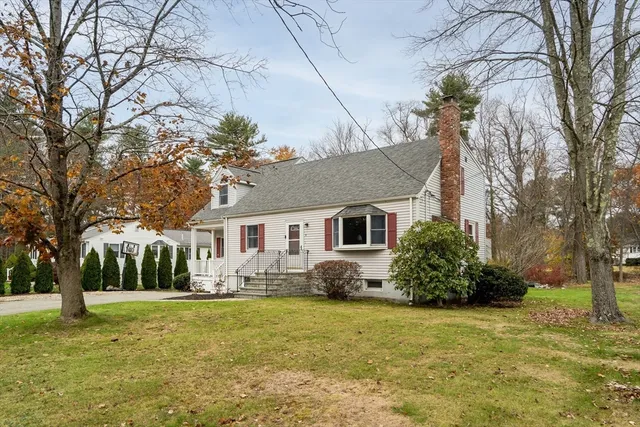 a front view of house with yard and trees around