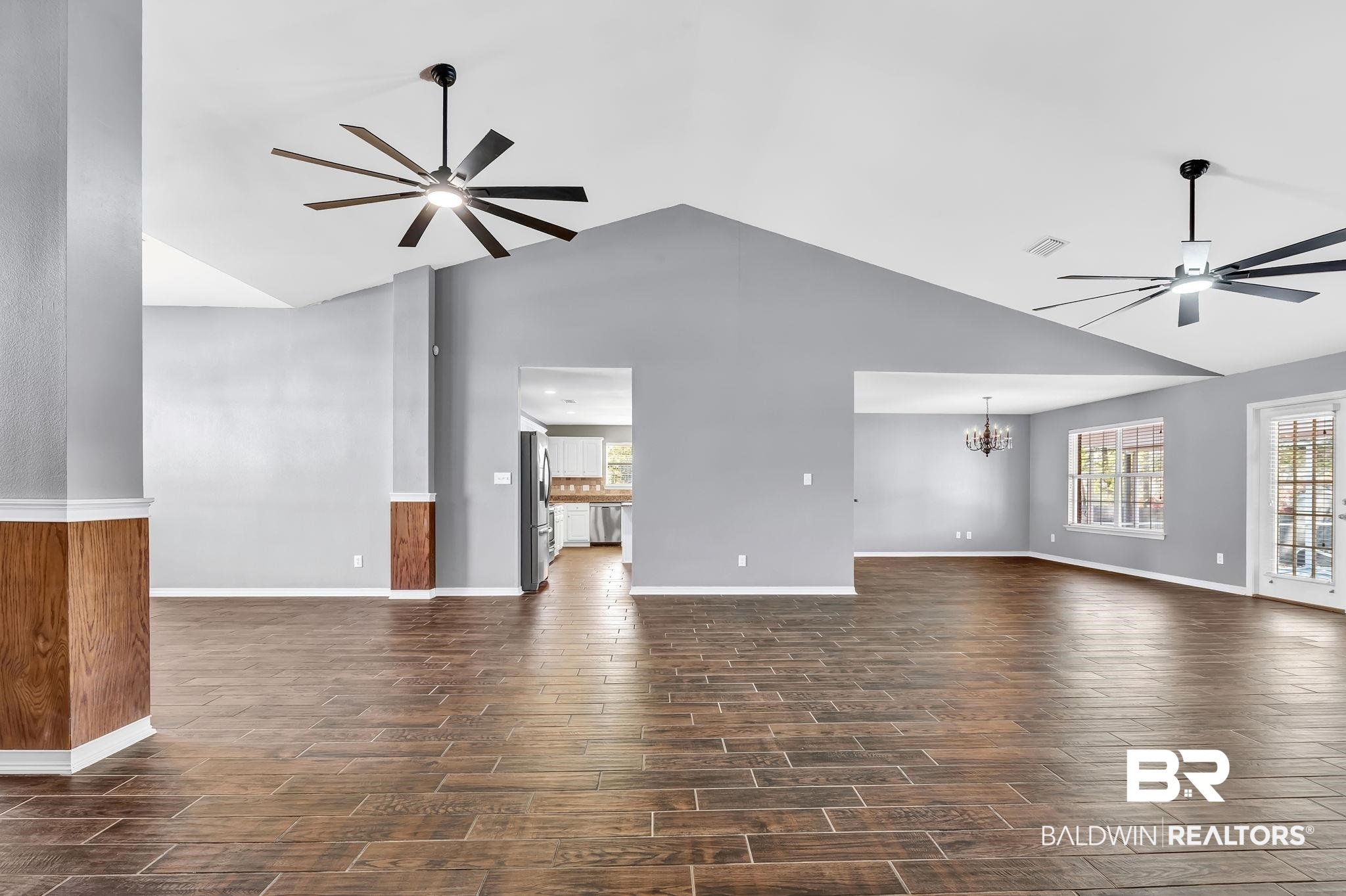 16444 Hamlet Lane Foley, AL 36535 - Photo 13 of 49 Unfurnished living room with ceiling fan with notable chandelier, baseboards, and dark wood finished floors