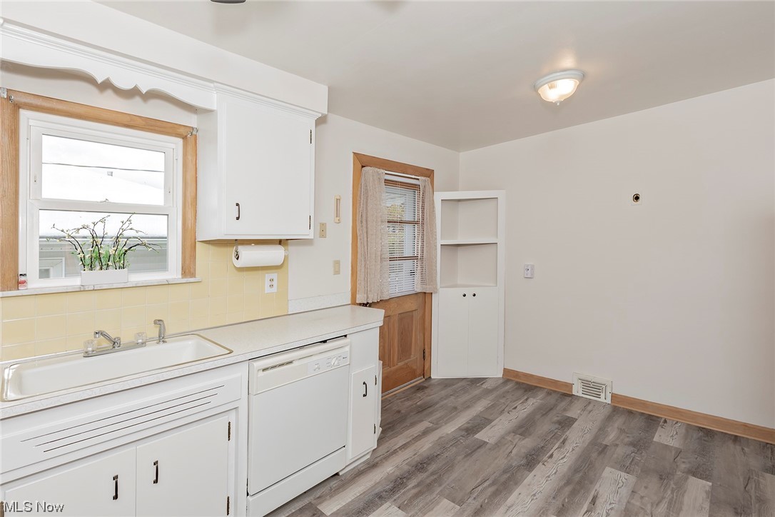963 Hanley Road Cleveland, OH 44124 - Photo 8 of 26 Kitchen featuring dishwasher, sink, light hardwood / wood-style flooring, backsplash, and white cabinetry