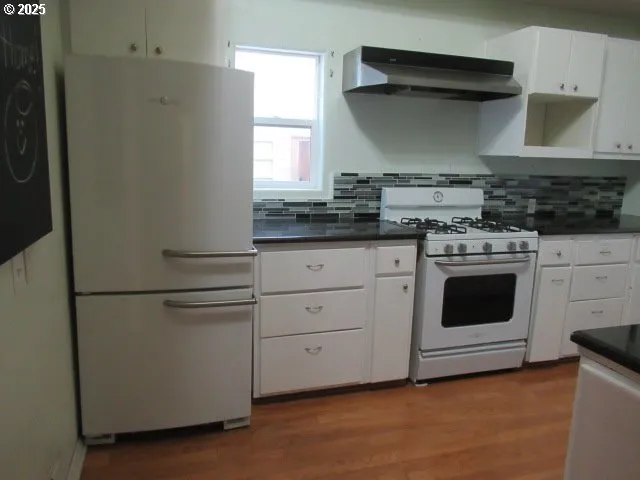 a kitchen with white cabinets and white appliances