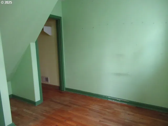 an empty room with wooden floor and closet