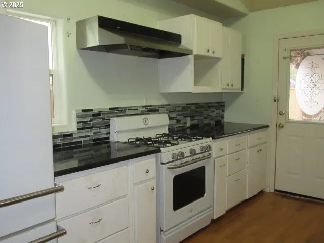 a kitchen with stainless steel appliances white cabinets and a stove