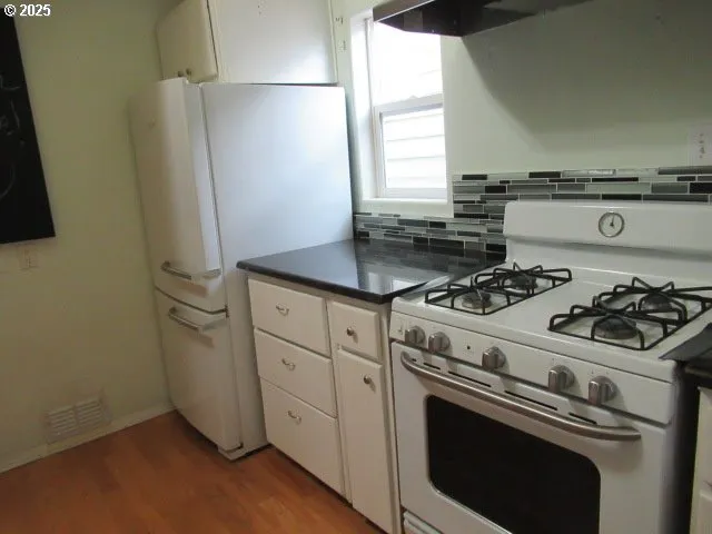 a white stove top oven sitting inside of a kitchen