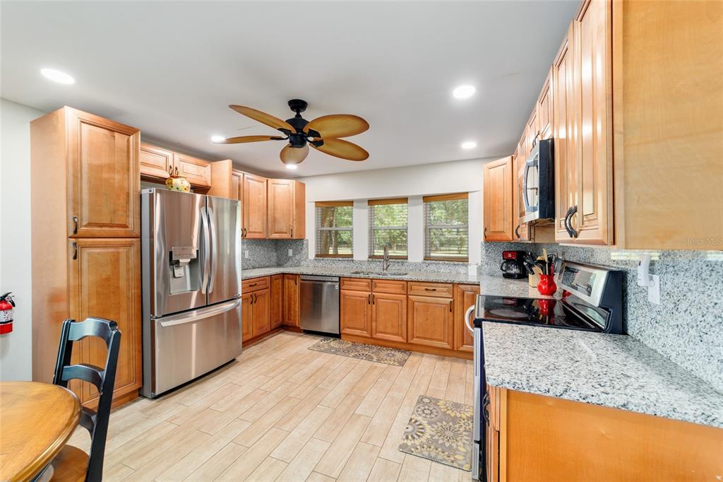 16520 Northwest 170th Street Williston, FL 32696 - Photo 49 of 98 a kitchen with stainless steel appliances granite countertop a refrigerator a oven a sink and dishwasher with wooden floor